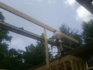 Carpenter setting a ridge beam over a new addition frame — Ice Dam Removal by Roofing Brothers in Creve Coeur