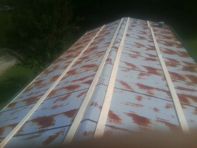 Rusted metal roof panels with new wood purlins before replacement — Storm Damage Roof Repair in Creve Coeur by Roofing Brothers