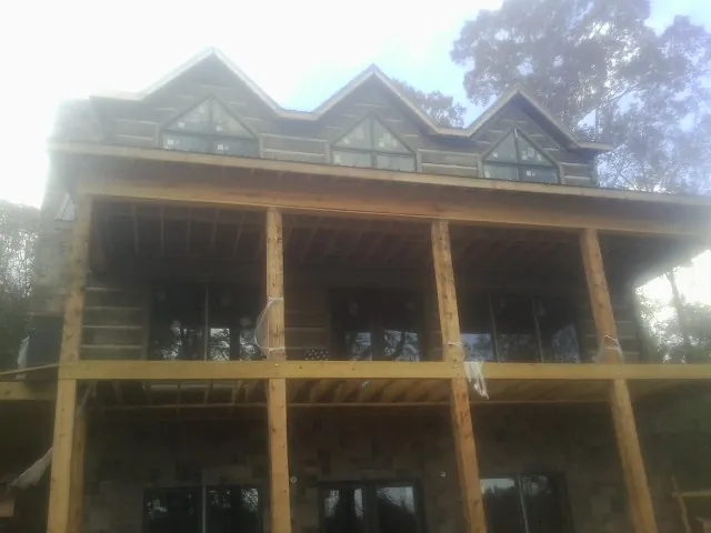 Dormers and porch framing on a large log home under construction — Roof Coating work by our crew in Creve Coeur