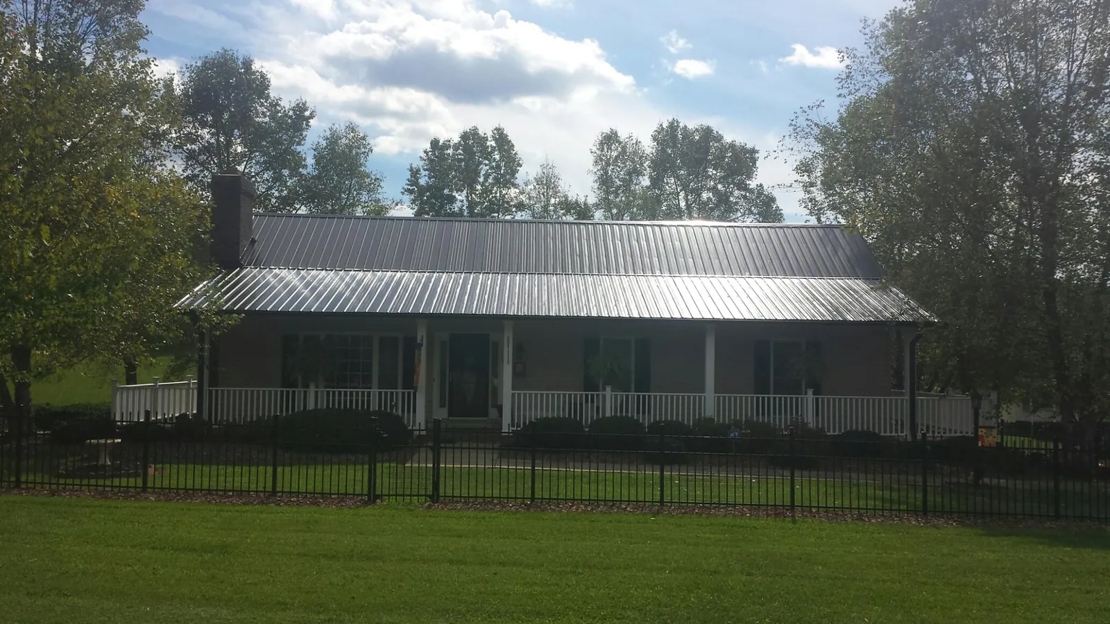 Gray metal roof on a brick ranch with a full width front porch — Gutter Guard Installation work by our crew in Creve Coeur